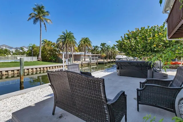 a roof deck with table and chairs and potted plants