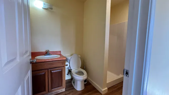 a bathroom with a granite countertop toilet and a sink