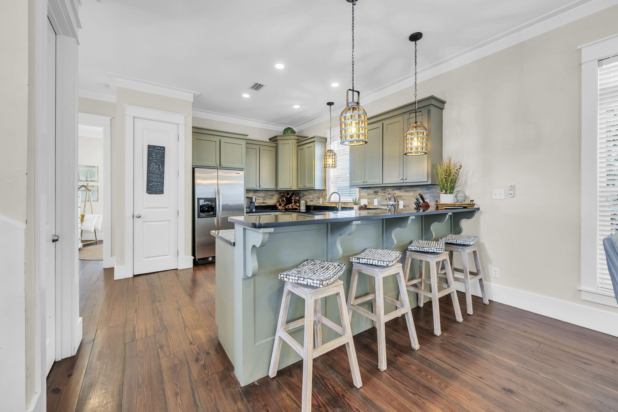 48 Cast Net Lane Seacrest, FL 32461 - Photo 4 of 41 a kitchen with stainless steel appliances granite countertop a kitchen island a stove a refrigerator and a dining table with wooden floor
