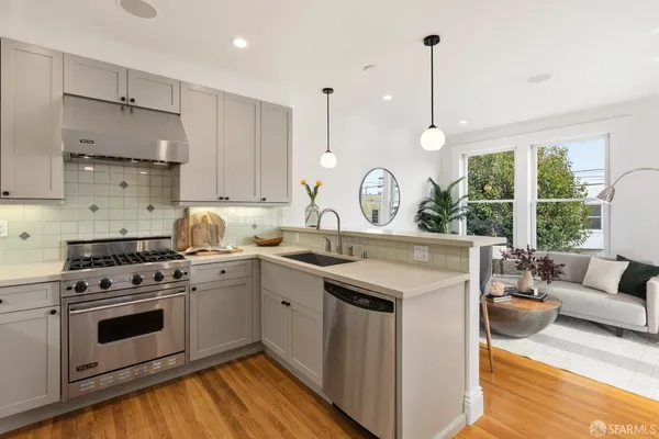 a kitchen with a stove a sink and a wooden floor