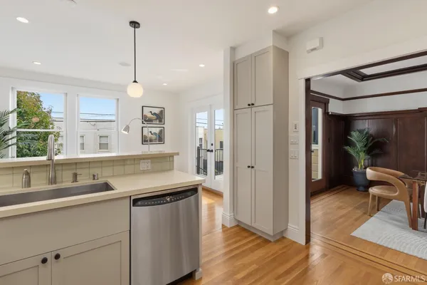 a kitchen with stainless steel appliances granite countertop a sink a stove and a wooden floor
