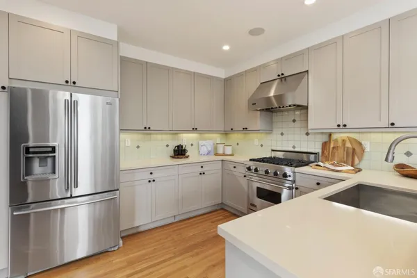 a kitchen with cabinets stainless steel appliances and wooden floor
