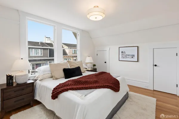 a spacious bedroom with a bed and a cabinets
