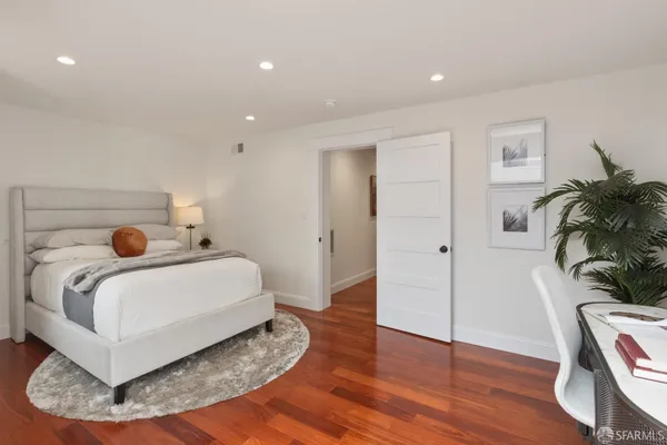 a bedroom with a bed and a potted plant