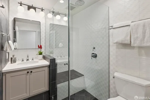 a bathroom with a sink toilet vanity and shower