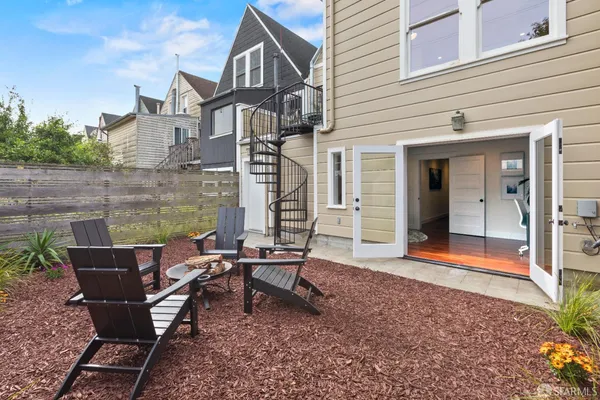 a view of a house with backyard and sitting area