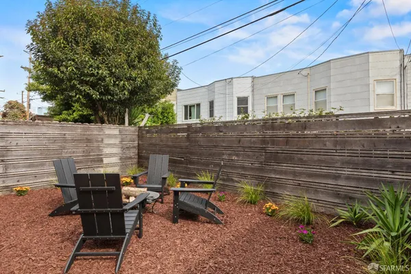 a view of a chairs and table in the back yard of the house
