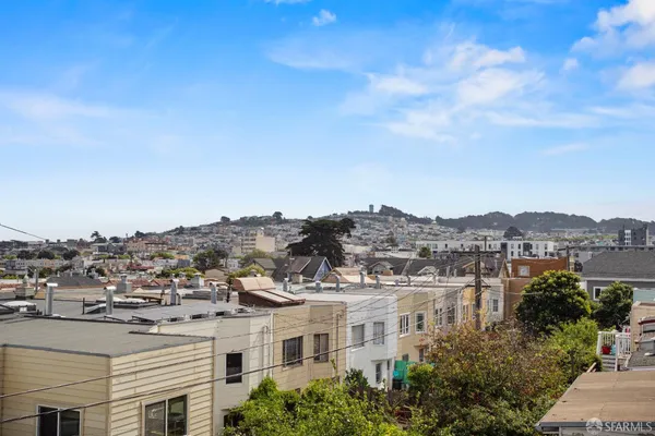 an aerial view of residential houses with a city view