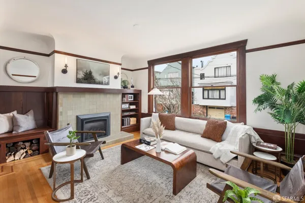 a living room with furniture a fireplace and a large window