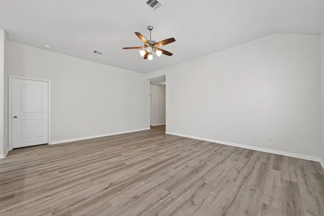 a large kitchen with cabinets wooden floor and stainless steel appliances