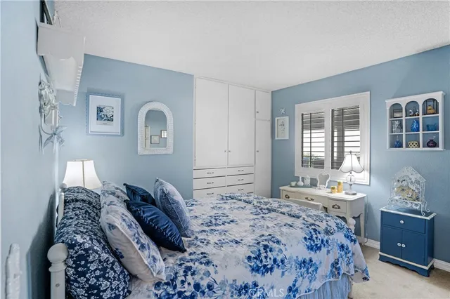 a bedroom with a bed window and dresser