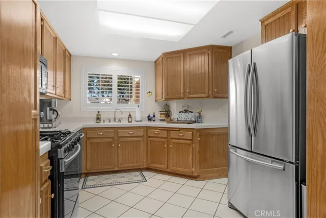 a kitchen with stainless steel appliances granite countertop a refrigerator sink and stove