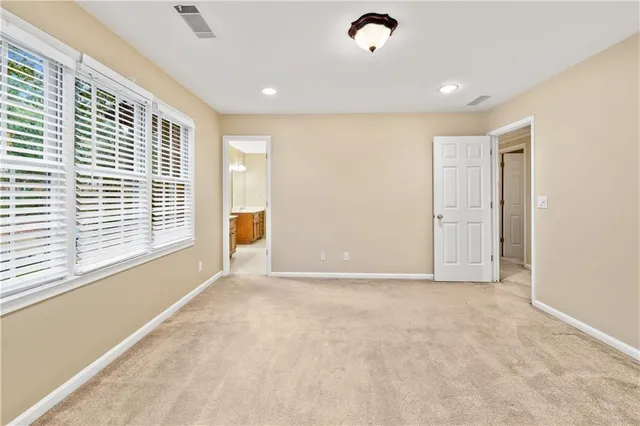 a view of an empty room with a fireplace and a window
