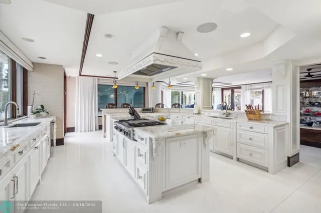 a large white kitchen with a stove and cabinets