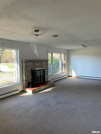 an empty room with a fireplace and window