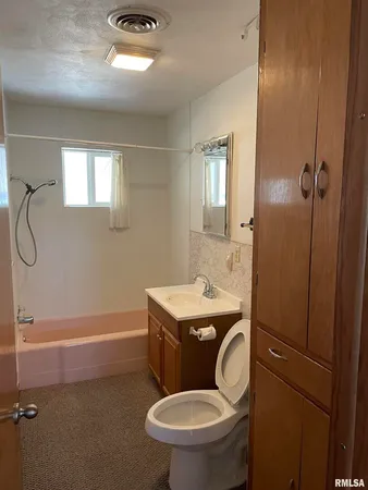 a bathroom with a granite countertop toilet sink and shower