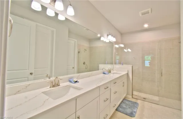 a spacious bathroom with a double vanity sink mirror and a bathtub
