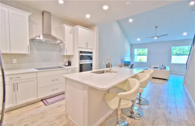 a large kitchen with cabinets a sink a window and stainless steel appliances