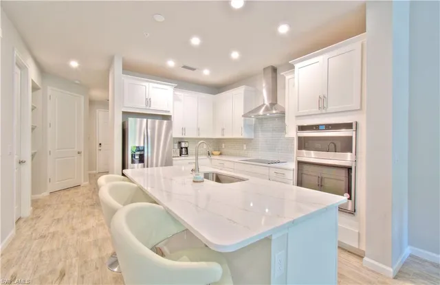 a kitchen with kitchen island stainless steel appliances a sink and cabinets