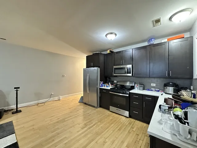 a kitchen with granite countertop wooden cabinets a stove top oven and refrigerator