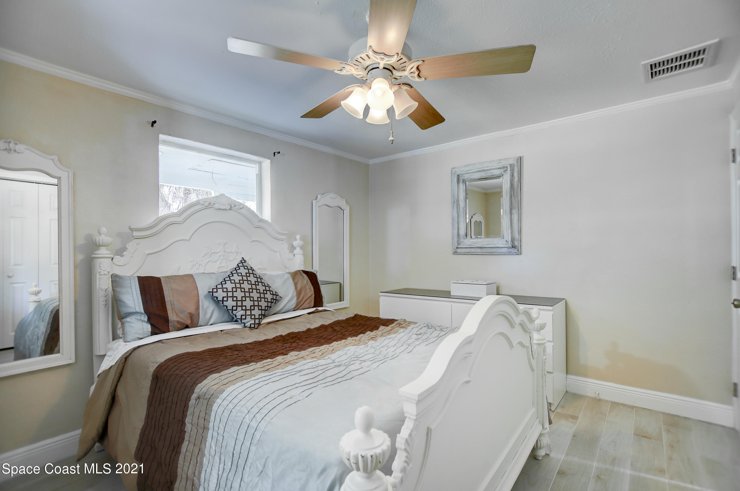 1896 Keewin Avenue Palm Bay, FL 32905 - Photo 15 of 23 a bed sitting in a bedroom and a chandelier