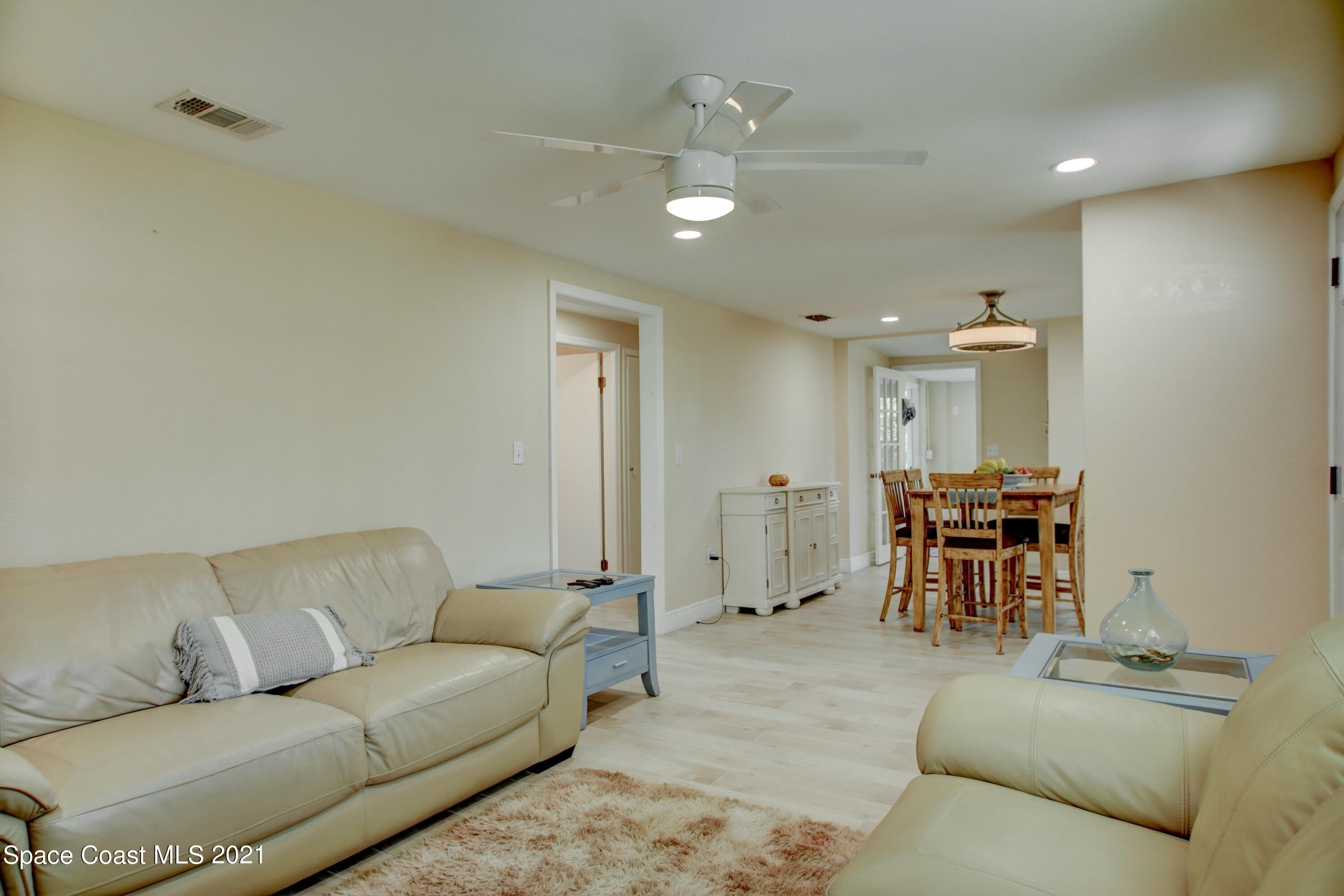 1896 Keewin Avenue Palm Bay, FL 32905 - Photo 4 of 23 a living room with furniture and a dining table with a sink