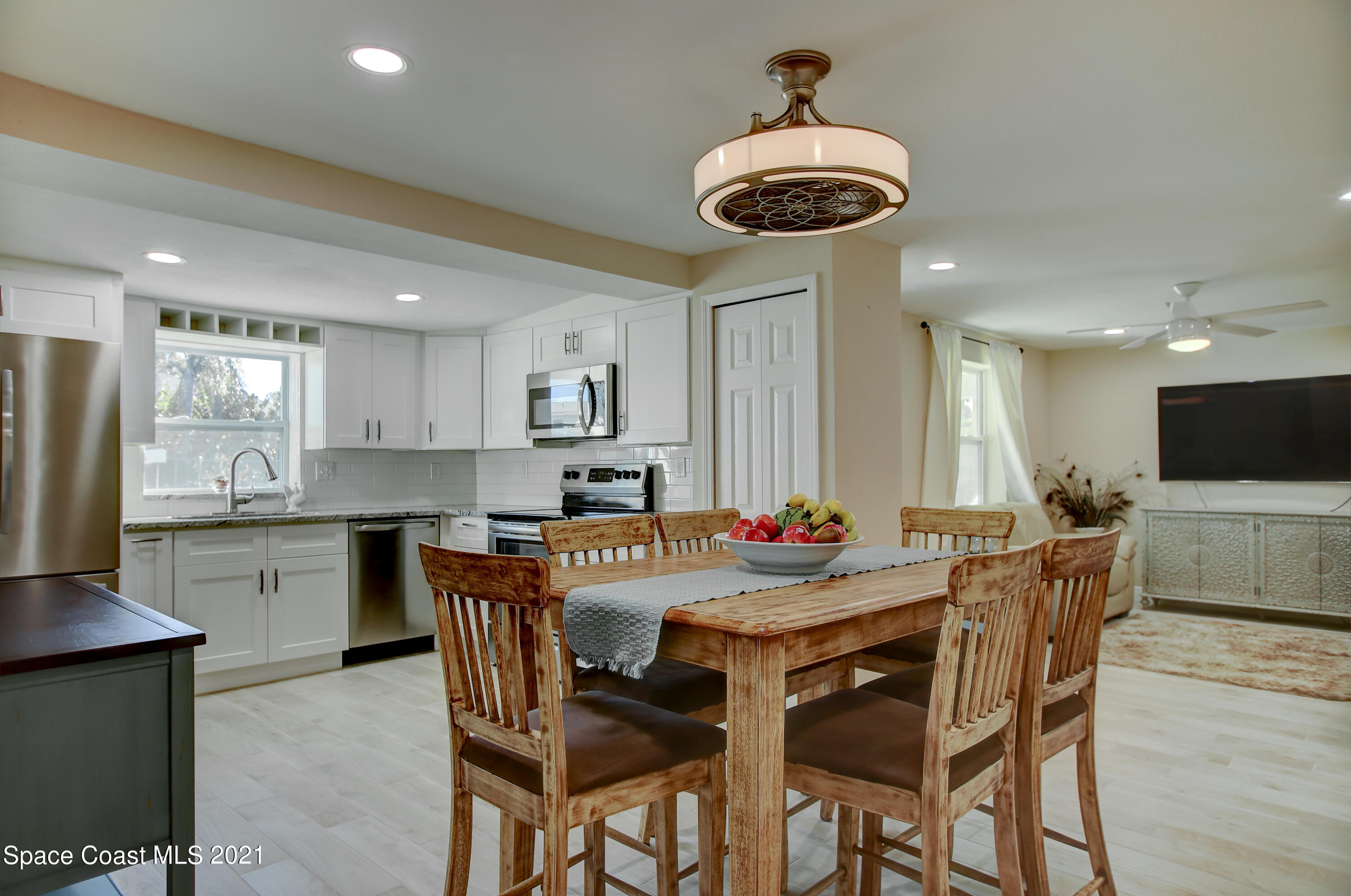 1896 Keewin Avenue Palm Bay, FL 32905 - Photo 7 of 23 a kitchen with stainless steel appliances a table and chairs in it