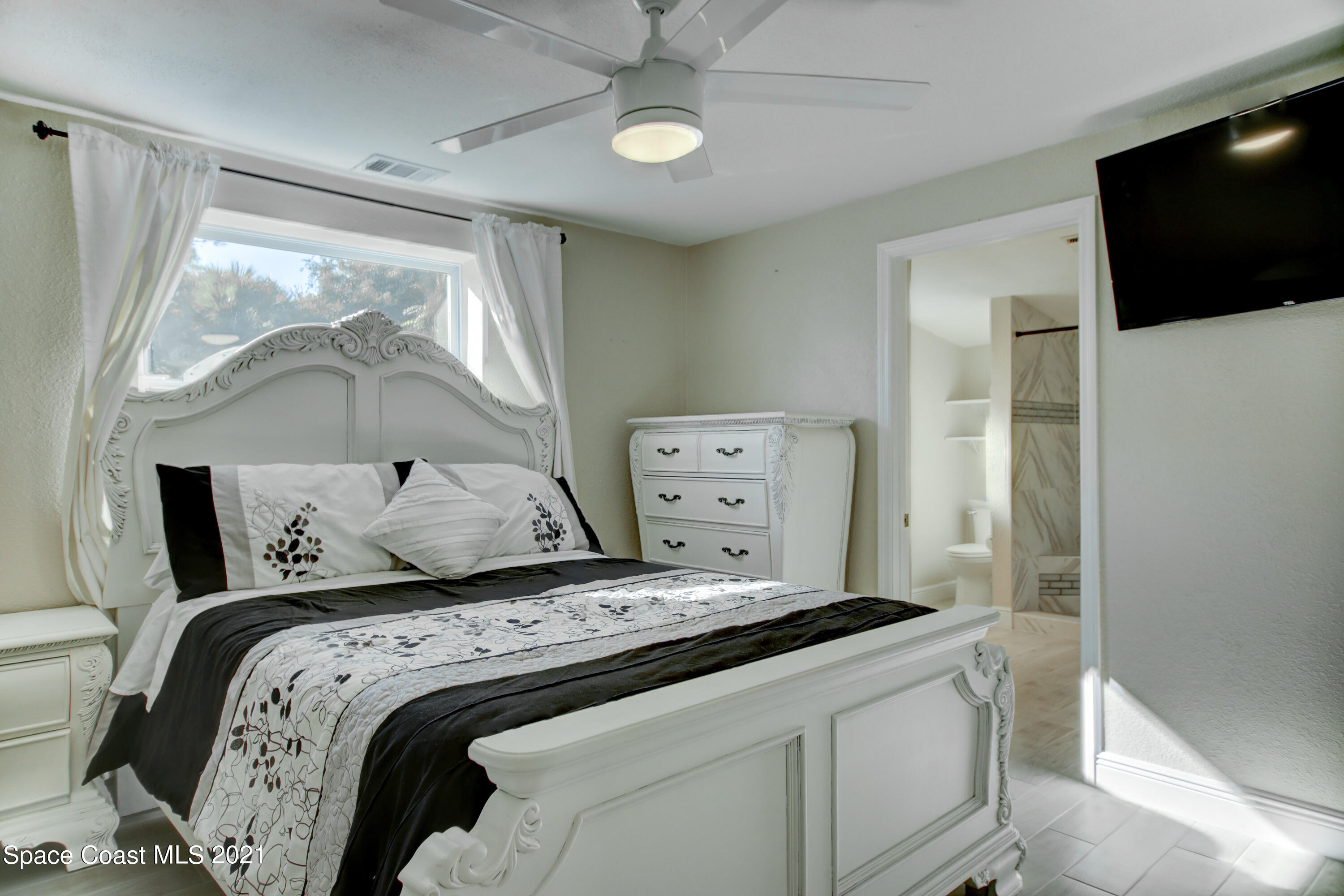 1896 Keewin Avenue Palm Bay, FL 32905 - Photo 9 of 23 a bedroom with a bed and a flat tv screen on dresser