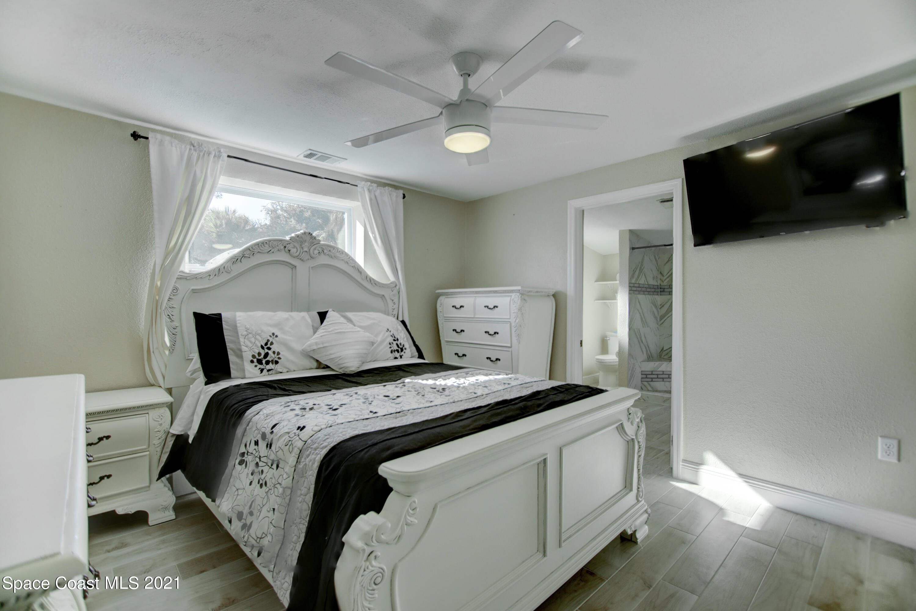 1896 Keewin Avenue Palm Bay, FL 32905 - Photo 10 of 23 a bedroom with a bed and a flat screen tv