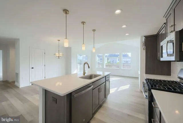 a kitchen with kitchen island a sink a counter top space and cabinets