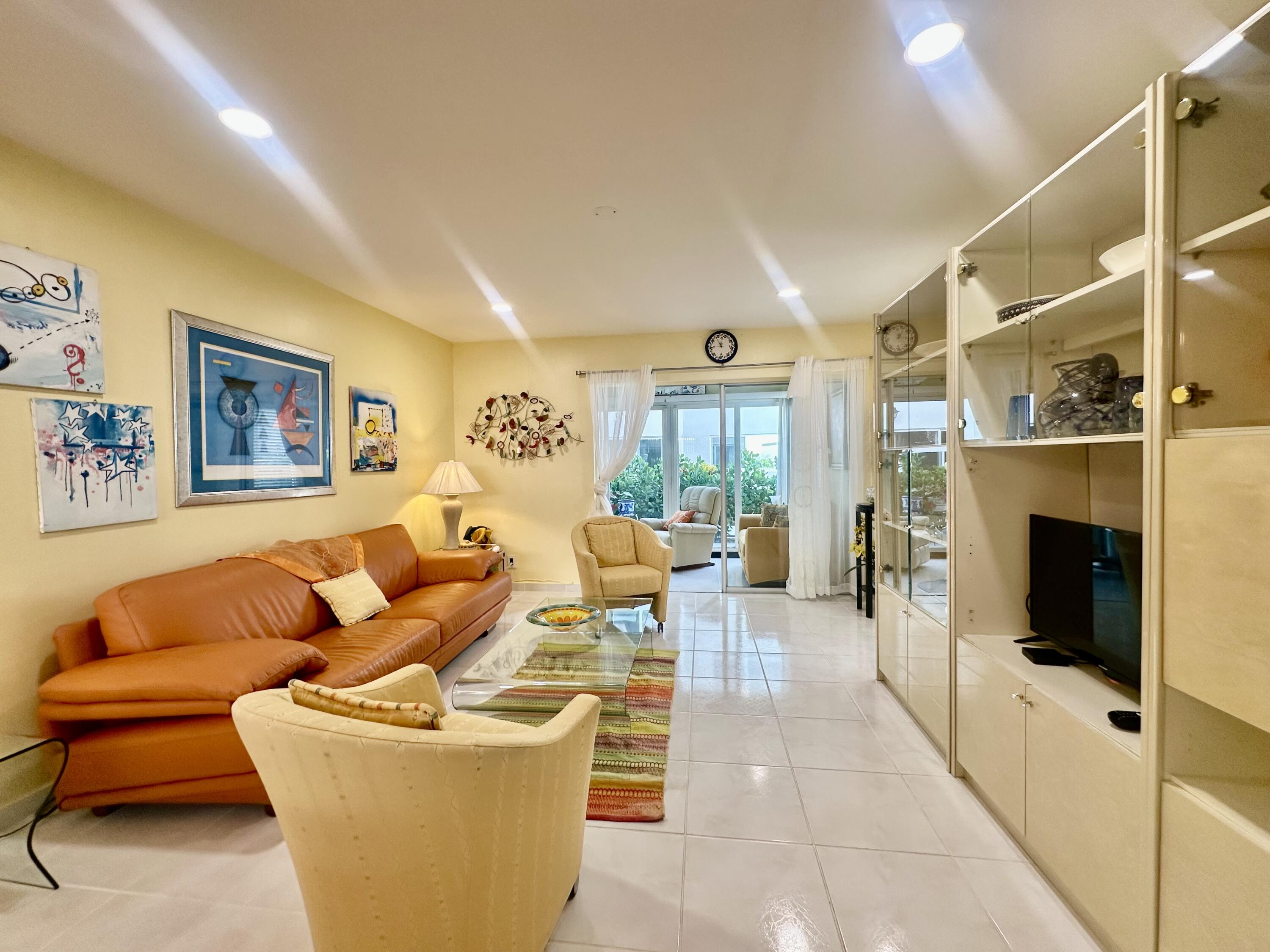 19 Colonial Club Drive, Unit 105 Boynton Beach, FL 33435 - Photo 4 of 53 a living room with furniture and a fireplace