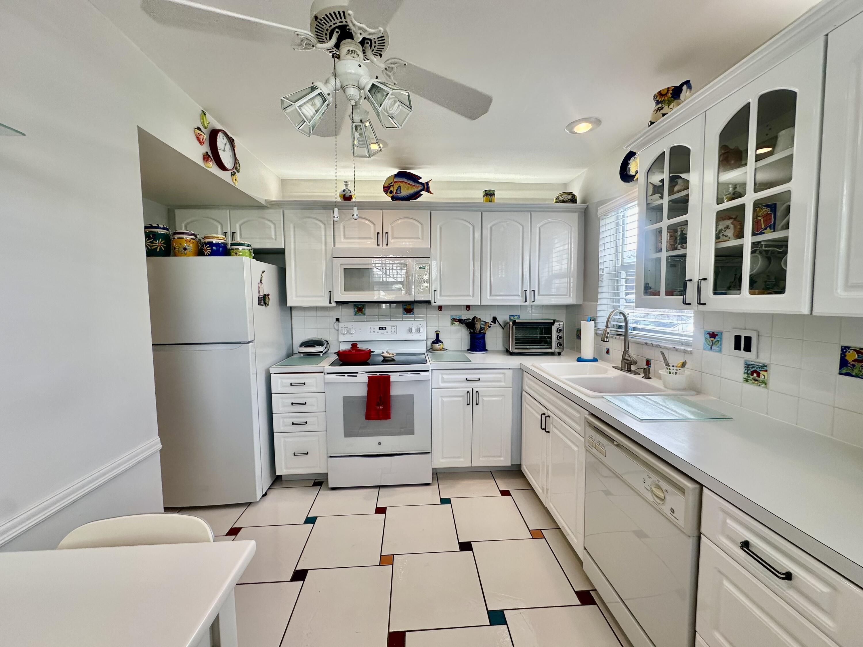 19 Colonial Club Drive, Unit 105 Boynton Beach, FL 33435 - Photo 8 of 53 a kitchen with stainless steel appliances a refrigerator sink and cabinets