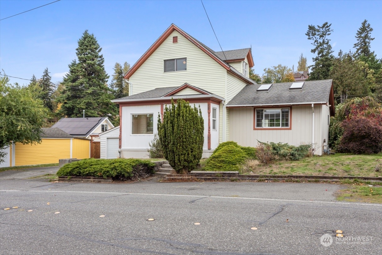 a front view of a house with a yard and potted plants