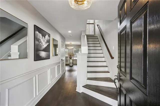 a hallway with white doors wooden floor and windows