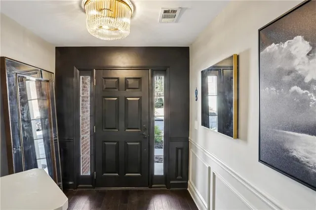 a view of a hallway with wooden floor and a bathroom
