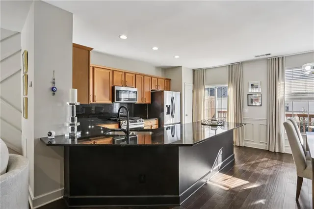 a kitchen with kitchen island granite countertop a stove refrigerator and cabinets