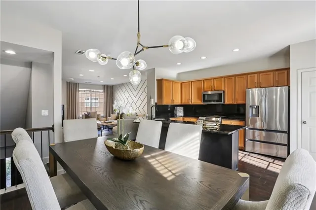 a view of a dining room and livingroom with furniture wooden floor a chandelier
