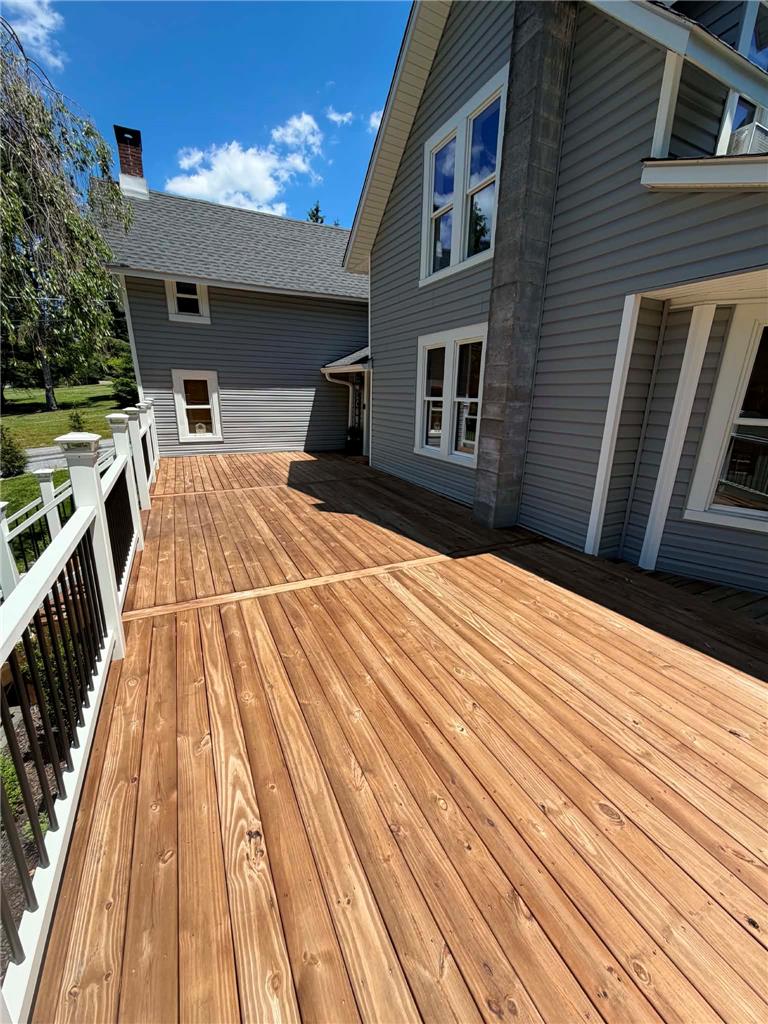 164 Sand Spring Road Cresco, PA 18326 - Photo 10 of 60 A spacious outdoor deck with railings extends from a traditional-style home, perfect for entertaining.