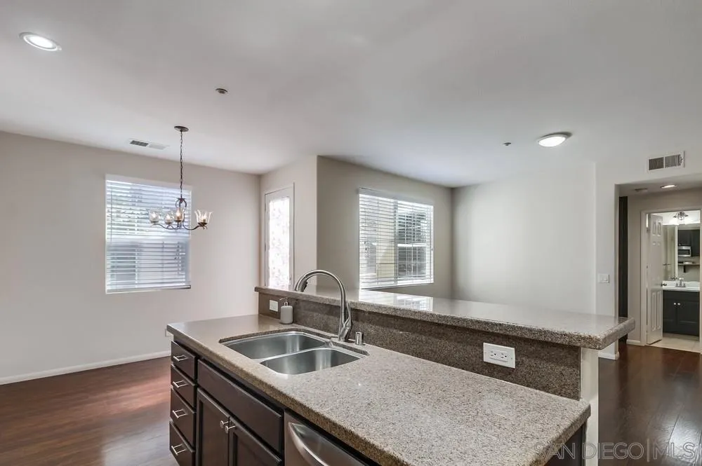 1298 Fools Gold Way, Unit 4 Chula Vista, CA 91913 - Photo 16 of 38 a kitchen with granite countertop a sink a window and stainless steel appliances
