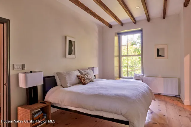 a bedroom with a bed a window and dresser