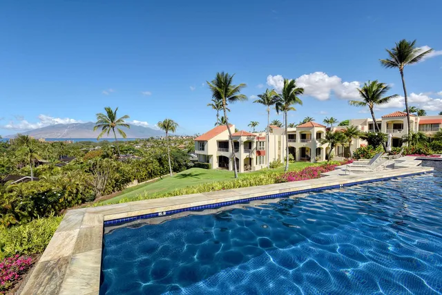 a view of a white house with a yard and potted plants