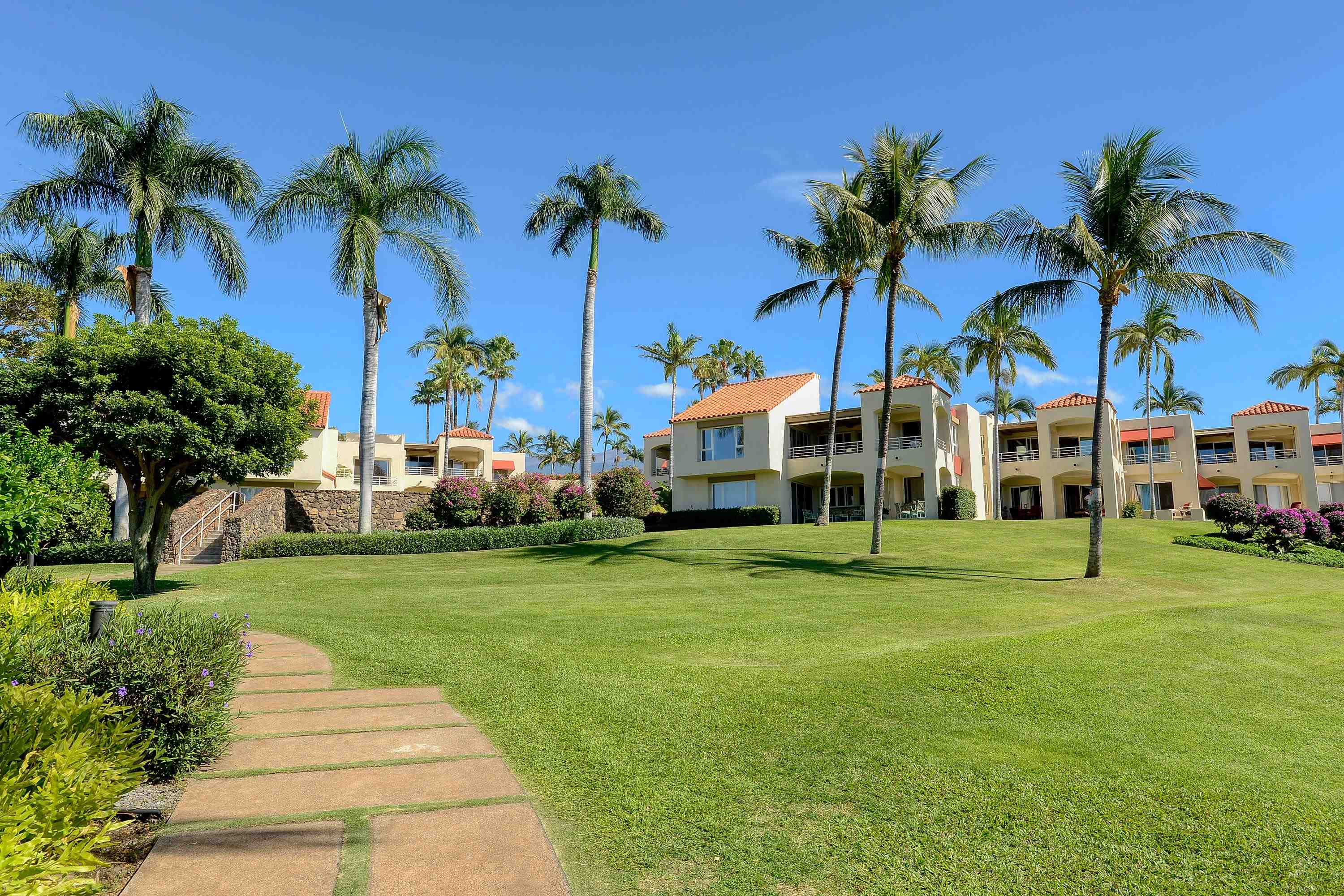 3150 Wailea Alanui Drive, Unit 3807 Kihei, HI 96753 - Photo 26 of 34 a front view of multi story residential apartment building with yard and green space
