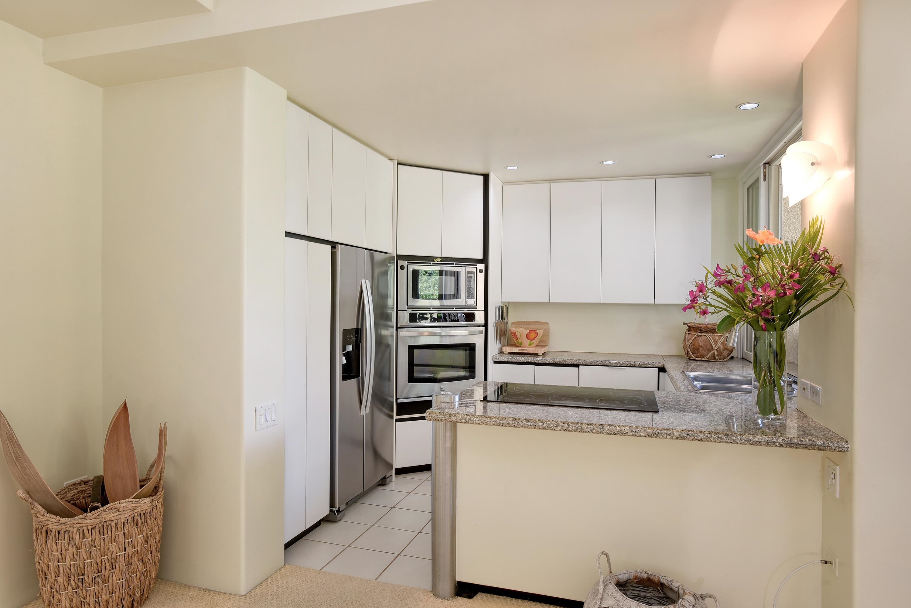 3150 Wailea Alanui Drive, Unit 3807 Kihei, HI 96753 - Photo 7 of 34 a kitchen with stainless steel appliances granite countertop a refrigerator and a sink