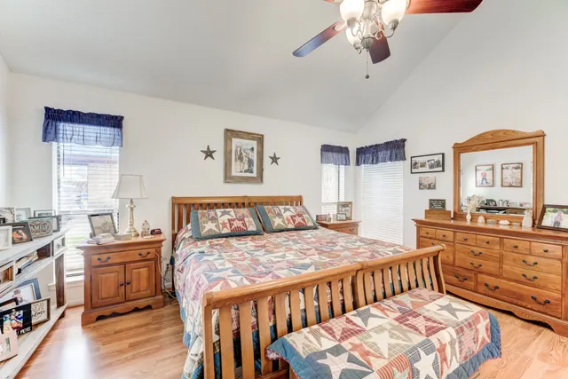 a bedroom with a bed a chandelier and dresser
