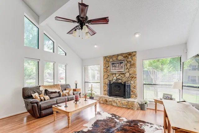 a living room with furniture a large window and a fireplace