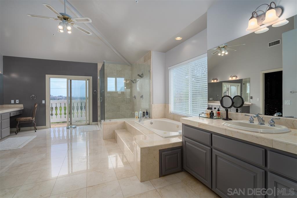7302 Vista Rancho Court Rancho Santa Fe, CA 92091 - Photo 12 of 22 a spacious bathroom with a double vanity sink a large mirror and shower