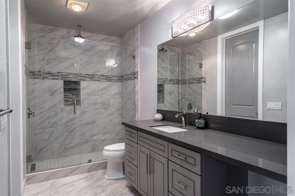7302 Vista Rancho Court Rancho Santa Fe, CA 92091 - Photo 14 of 22 a bathroom with a granite countertop sink a toilet and shower