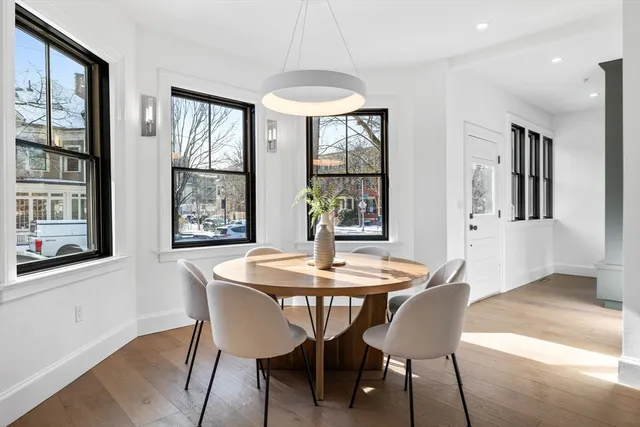 a dining room with furniture a chandelier and wooden floor