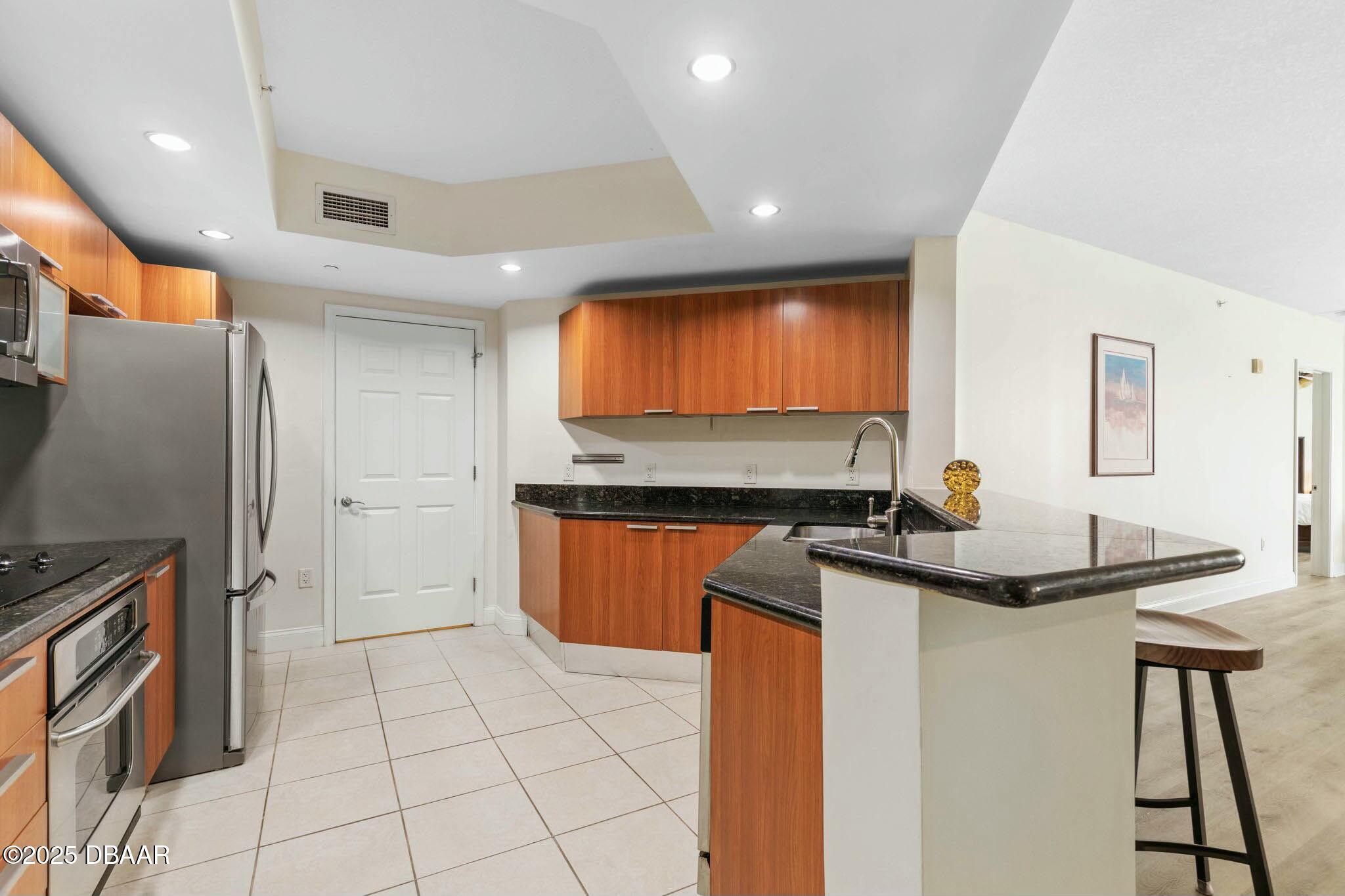 231 Riverside Drive, Unit 1104 Holly Hill, FL 32117 - Photo 19 of 77 a kitchen with stainless steel appliances a sink stove and refrigerator