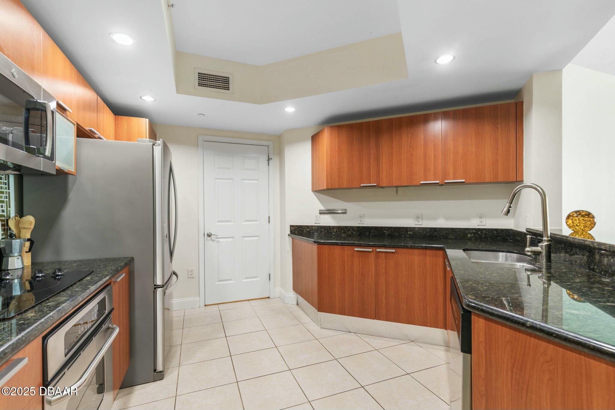 231 Riverside Drive, Unit 1104 Holly Hill, FL 32117 - Photo 20 of 77 a kitchen with stainless steel appliances granite countertop a sink and a stove